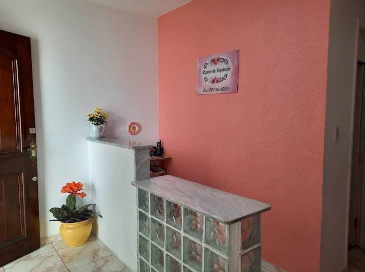 Entrada e balcão de atendimento do Espaço de Depilação com vasos de flores