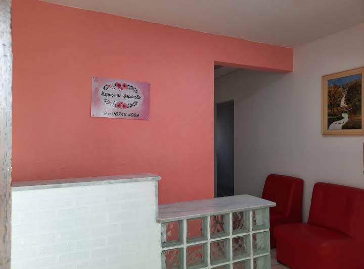 Recepção do Espaço de Depilação, com poltronas e placa do estabelecimento